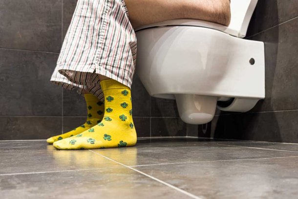 Man zittend op toilet