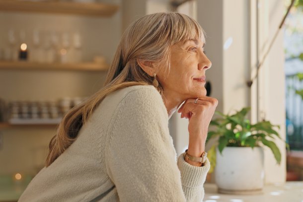 oudere vrouw kijkt uit raam