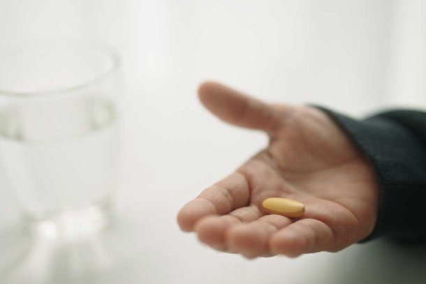 Vrouw met een vitamine c supplement in haar hand