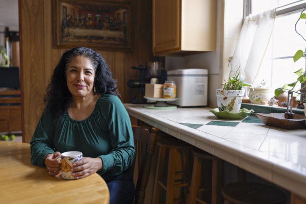 Oudere dame zit in de keuken