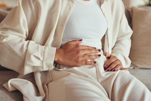 Vrouw met hand op haar buik omdat ze pijn heeft
