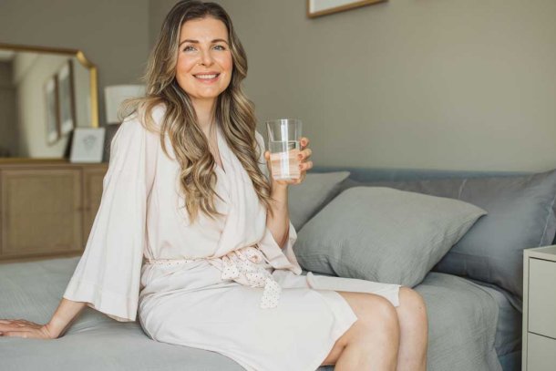 vrouw op bed in badjas