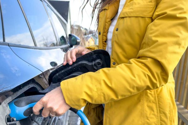 Vrouw laadt elektrische auto op