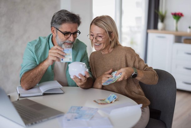 Ouderen tellen hun geld in de keuken met spaarvarken
