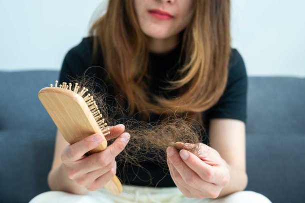 Een vrouw haalt haar uit haar borstel
