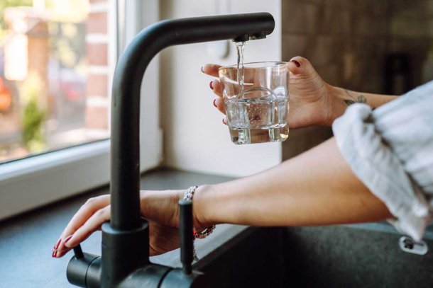 Vrouw tapt glas kraanwater
