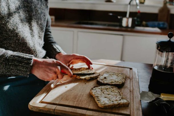 Man smeert boter op brood