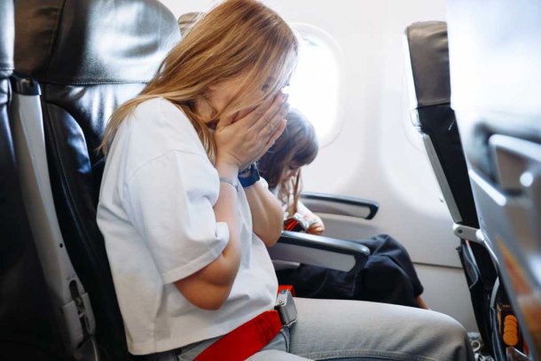 Vrouw met reisziekte in het vliegtuig