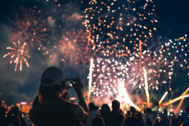Vrouw kijkt met telefooncamera naar vuurwerkshow