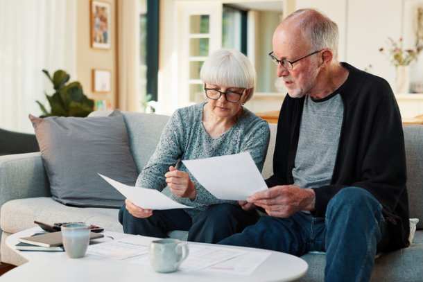 Man en vrouw kijken door papieren zorgverzekering