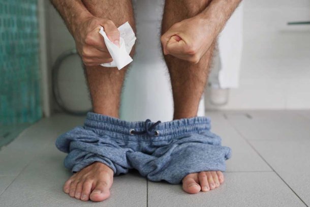 Man zit op het toilet met obstipatie