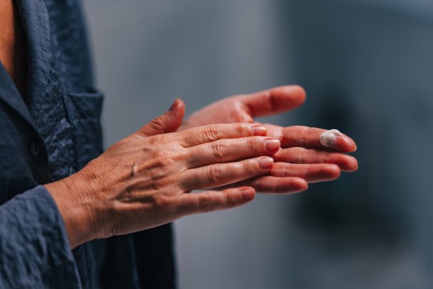 oudere vrouw smeert handen in