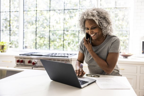 Vrouw met grijze afro zit achter laptop