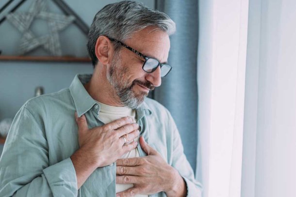 Man grijpt naar zijn borst. Hij heeft pijn. Is het zijn hart?