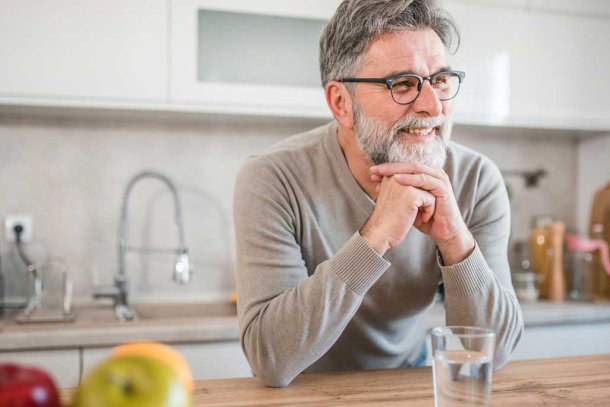 man drinkt water uit een glas in de keuken