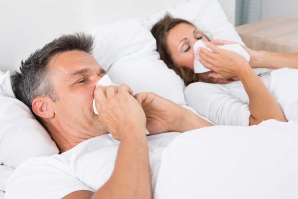 Man en vrouw liggen samen in bed met griep