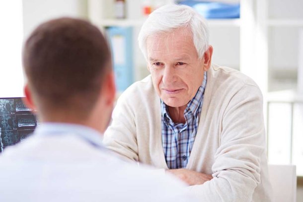 Man in gesprek met arts over zijn fysieke klachten