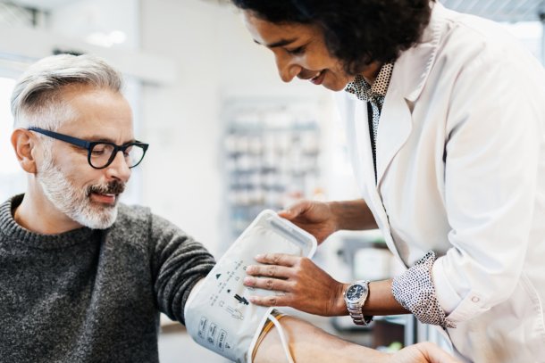 man laat bloeddruk meten door arts