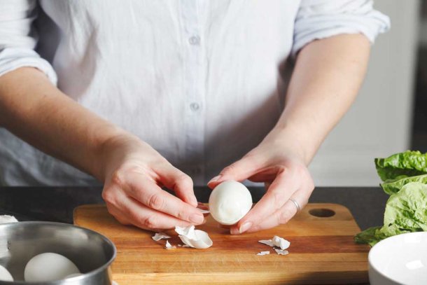 Vrouw pelt hardgekookt ei