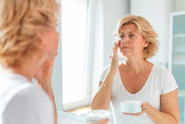 Vrouw smeert creme op haar gezicht