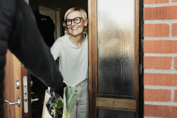 oudere vrouw krijgt boodschappen bezorgd
