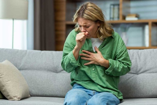 hoestende vrouw op de bank