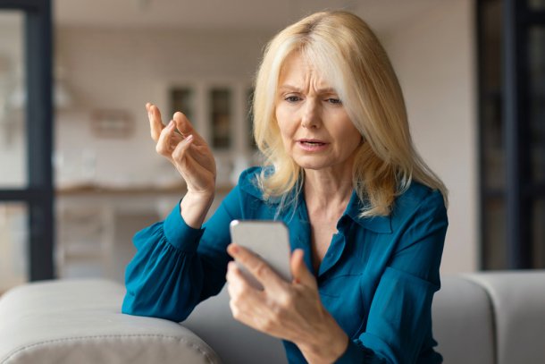 vrouw kijkt zorgelijk naar telefoon