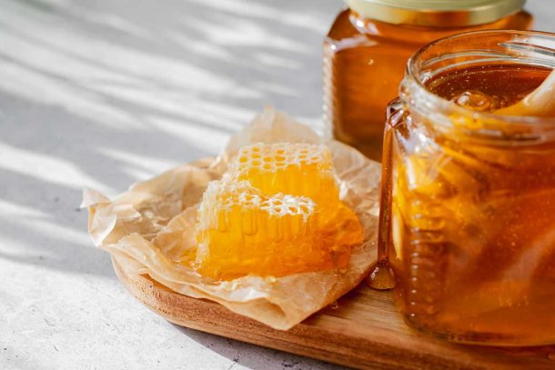 Honing in een potje op een houten plank