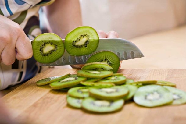 Vrouw snijdt kiwi's