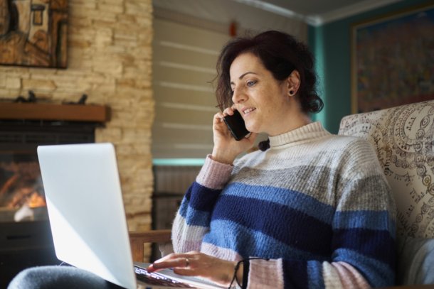 Vrouw zit op de bank met laptop