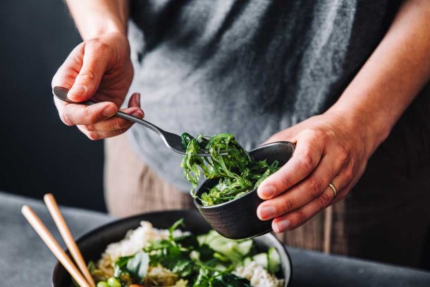 vrouw maakt salade met zeewier