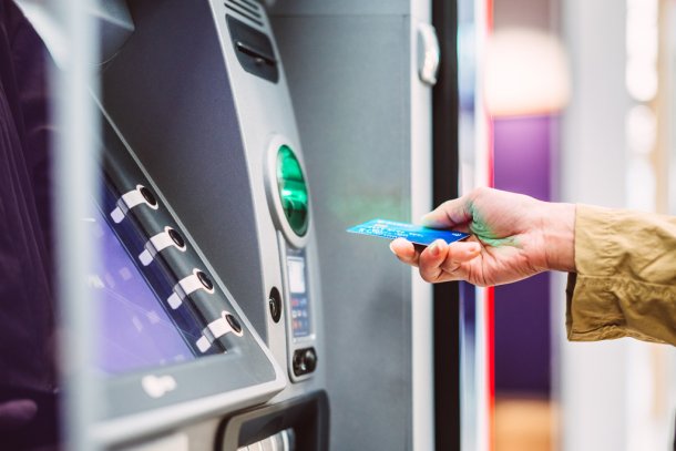 Vrouw pint geld uit betaalautomaat