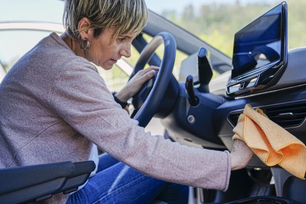 oudere vrouw maakt auto van binnen schoon