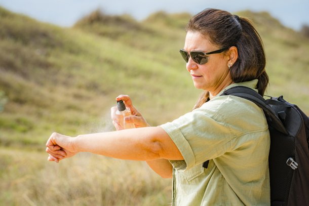 oudere vrouw spuit zich in tegen insectenbeten