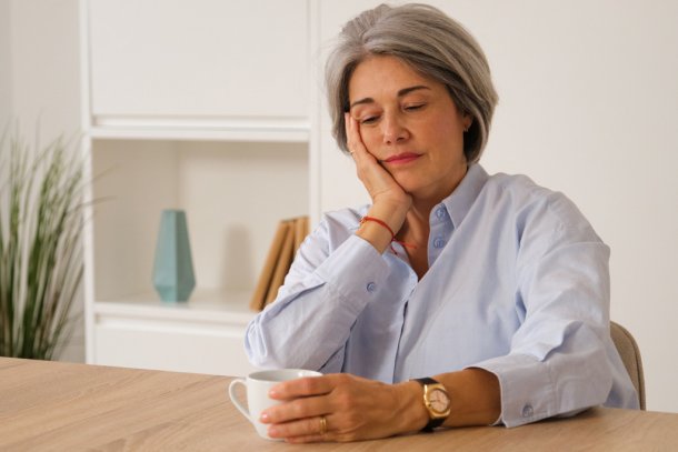 Vrouw voelt zich somber en schuldig drinkt een kop thee of koffie