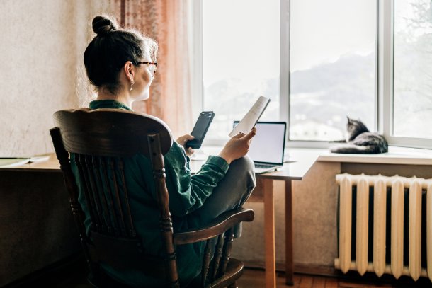 Vrouw is thuis aan het werk, kat op de vensterbank