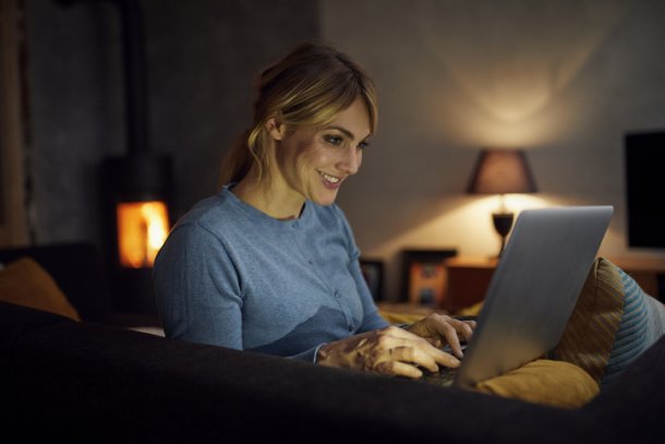 Vrouw gebruikt laptop in de slaapkamer