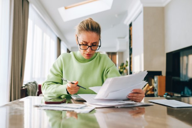 Knappe oudere vrouw doet thuis de belastingaangifte