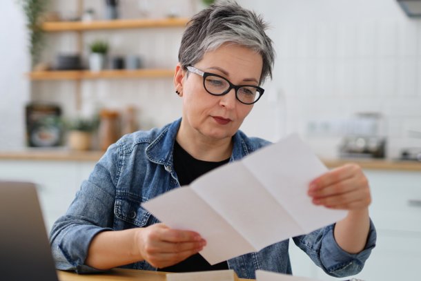 oudere vrouw bekijkt lijst op papier