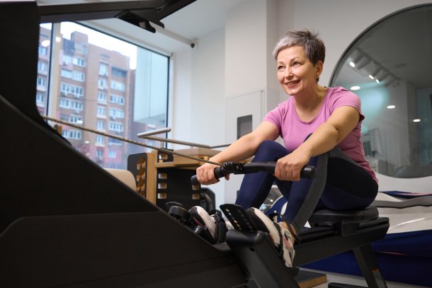 oudere vrouw op roeiapparaat