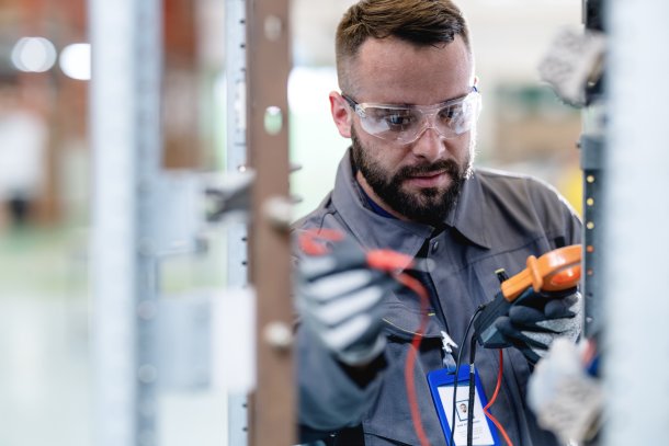 Mannelijke electricien fikst stroomnet